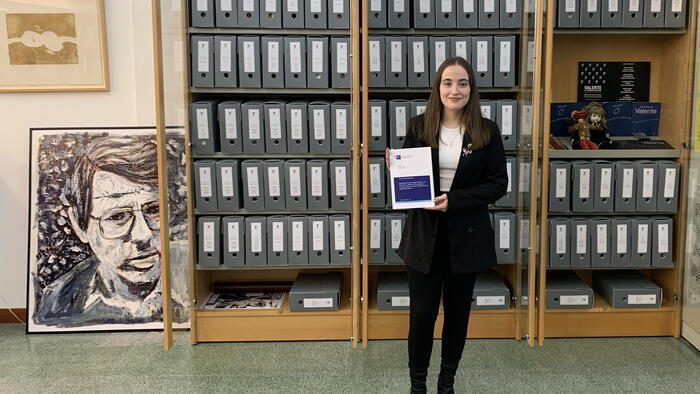 Laura Paz Fentanes posa coa súa tese e a carón dun retrato de Valente