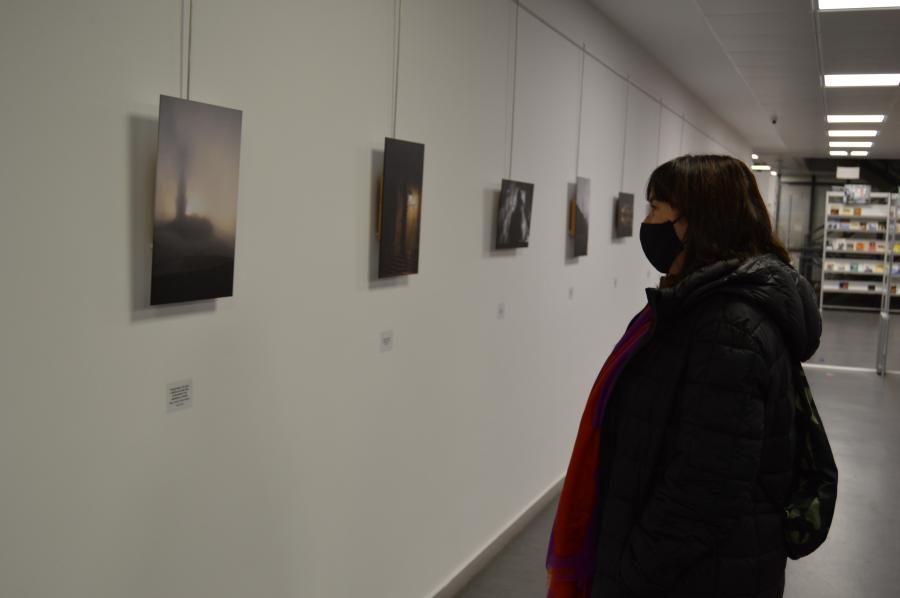 Unha participante no certame olla a súa fotografía na mostra aberta na biblioteca Nodal de Lugo