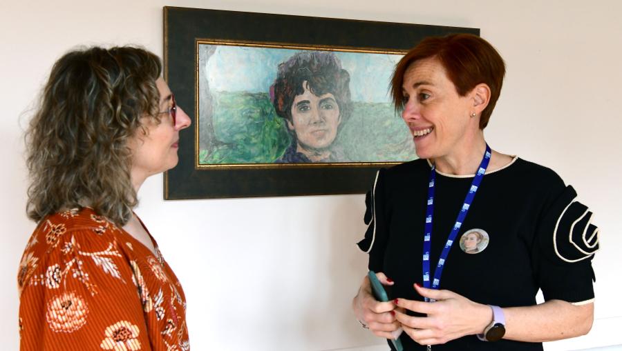 A pintora Elsa Martínez, esquerda, conversa coa vicerreitora Pilar Murias ante o retrato de Rosalía. FOTO: Santi Alvite