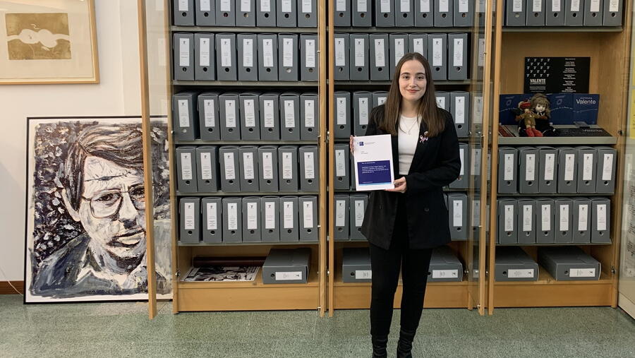 Laura Paz Fentanes posa coa súa tese e a carón dun retrato de Valente