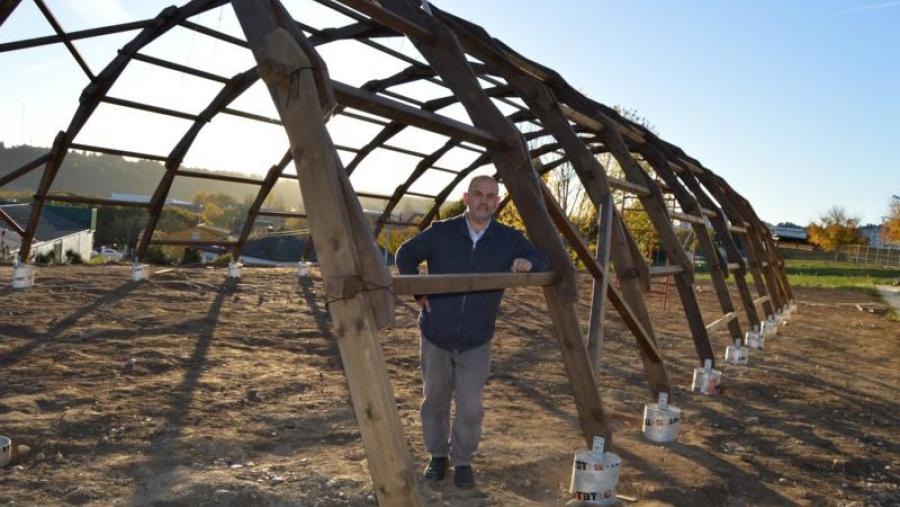 Xan Neira, apoiado na estrutura do invernadoiro ecolóxico montado na finca de prácticas do Campus Terra da USC